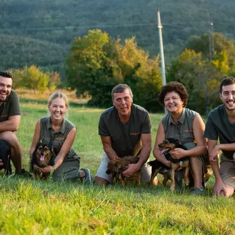 A family of five, each crouching with a small dog.