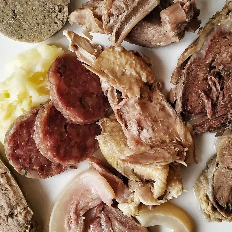 a selection of sliced cooked meats on a plate