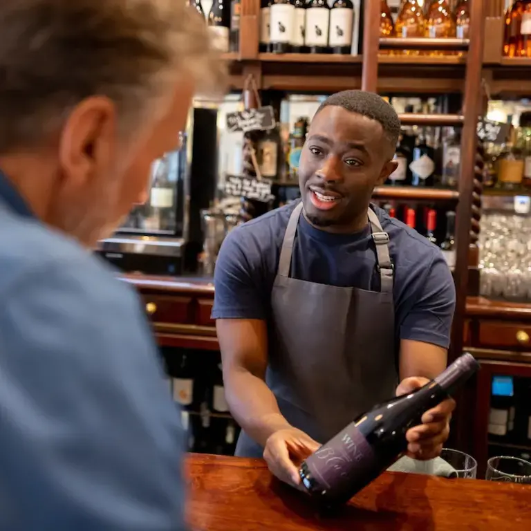 Man cheating and making friend with bartender from restaurant staff