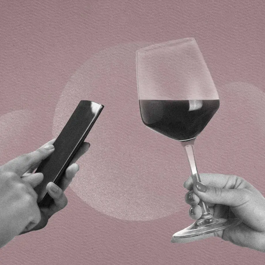 A mobile phone and wine glass.