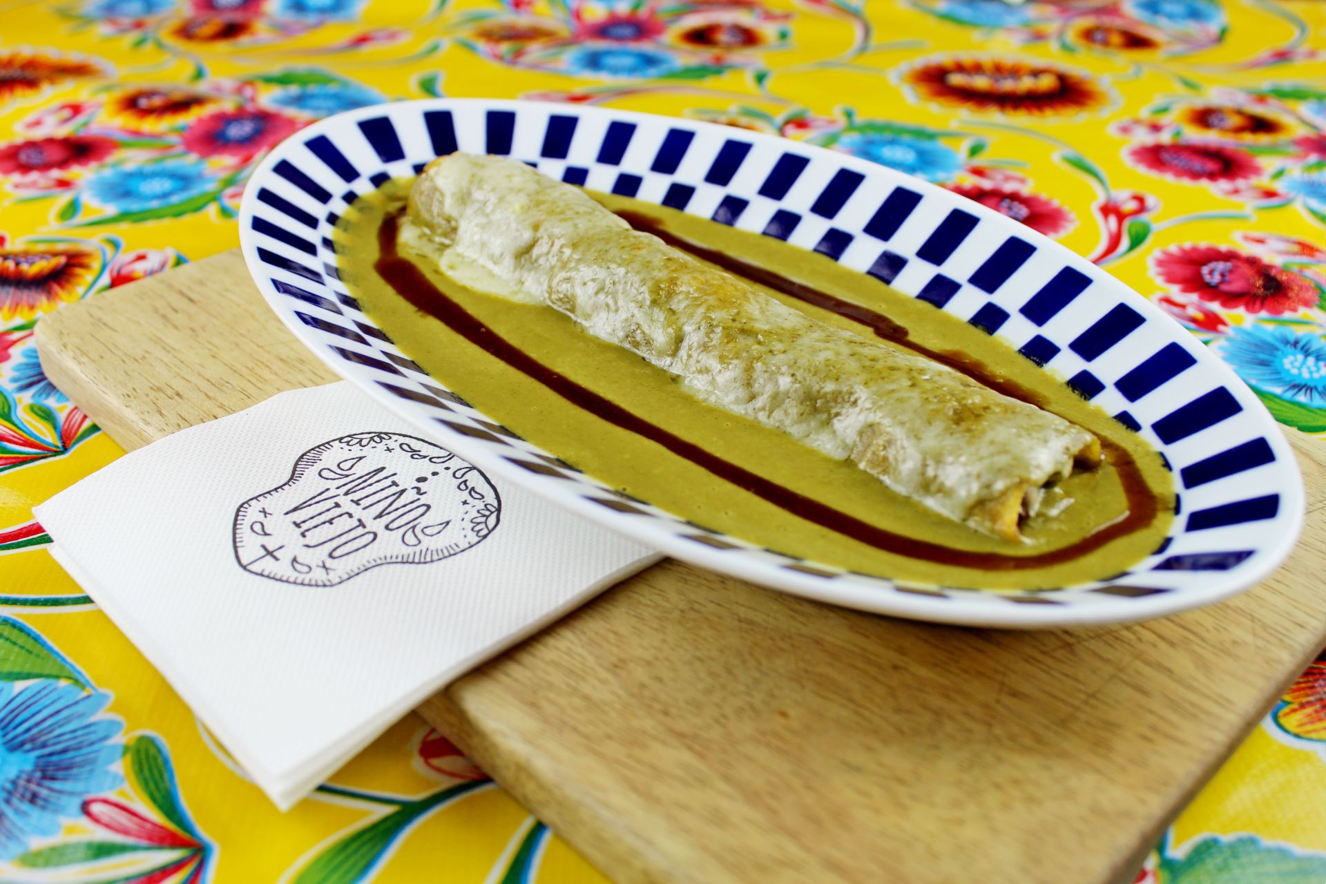 A dish with food, on a colourful table.