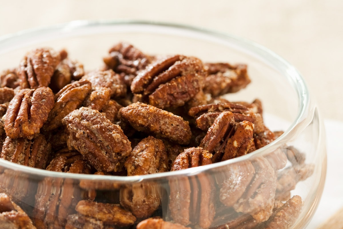 a bowl of spiced candied pecans