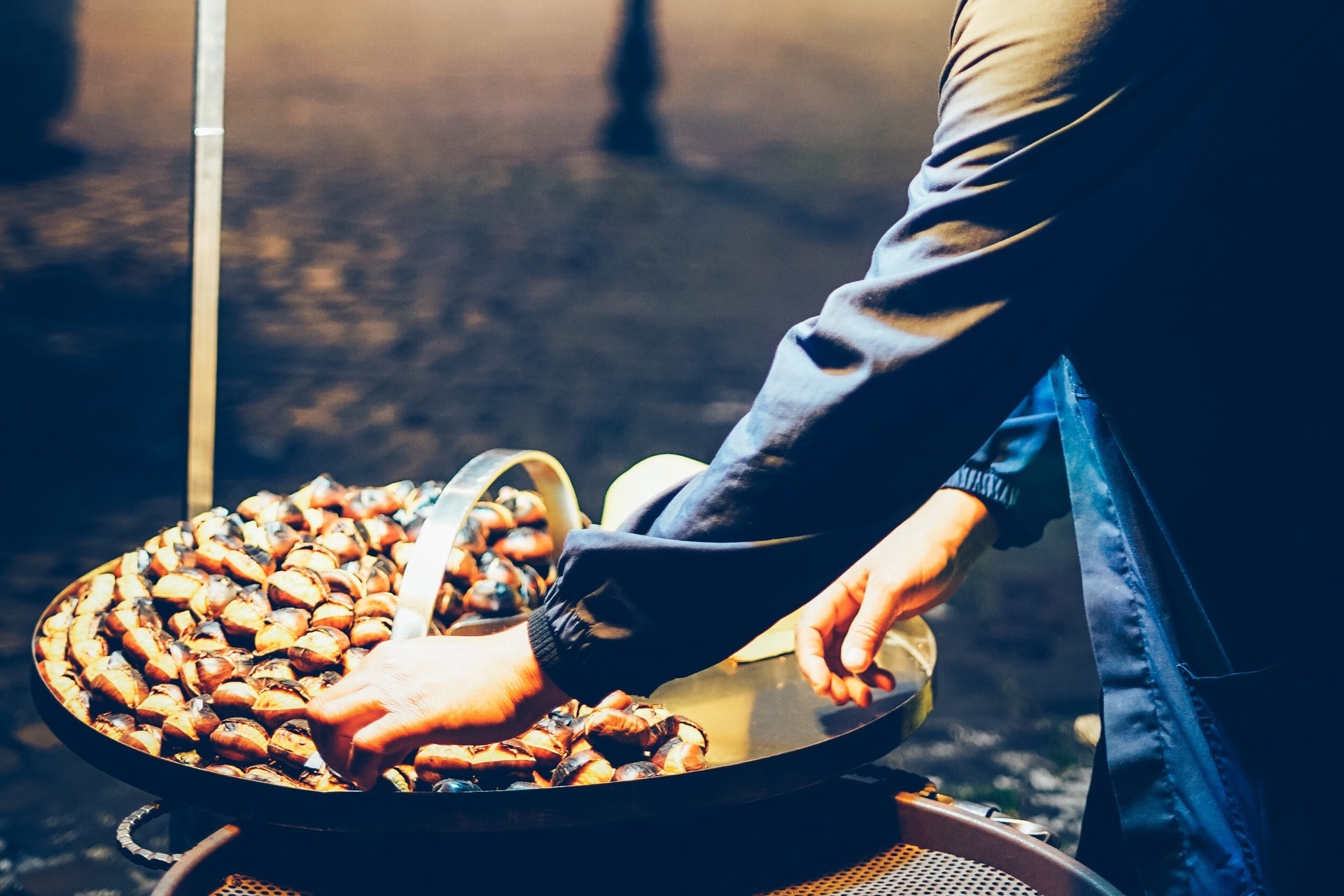 chestnuts being roasted on a hot plate on the street